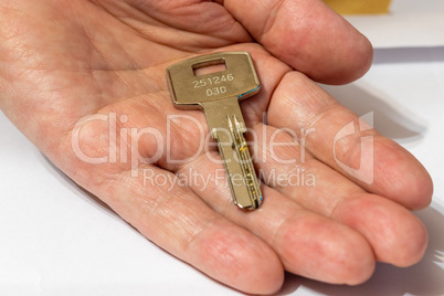 One metal key lies on the palm of your hand
