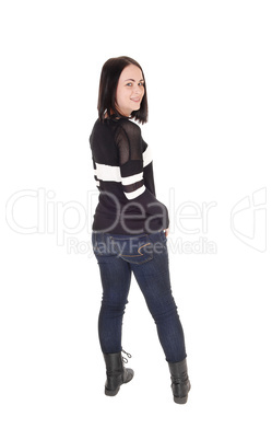 Pretty young woman standing in jeans from back