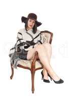 Beautiful young woman sitting in chair with hat