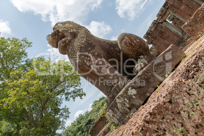 Angled view of stone lion guarding temple