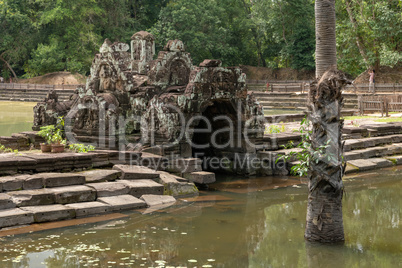 Arched stone monument and steps by pond