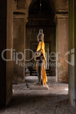 Buddha statue standing in Angkor Wat corridor