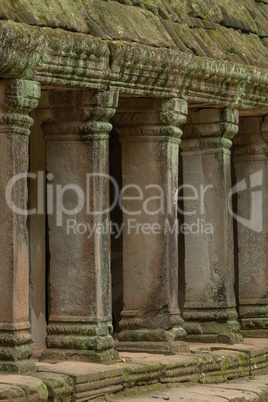 Colonnade of stone pillars under mossy roof