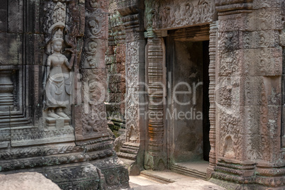 Decorated stone entrance to temple opposite statue