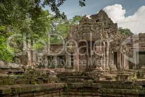 Facade of ruined stone temple in trees