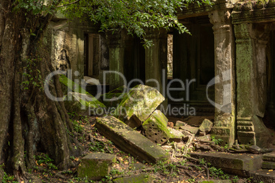 Fallen rocks by statue in temple wall