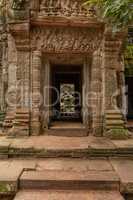Fallen rocks seen through stone temple doorway