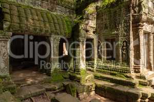 Moss-covered columns and statues by temple doorway