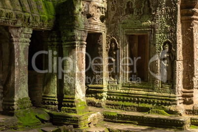 Moss-covered columns and statues in temple wall