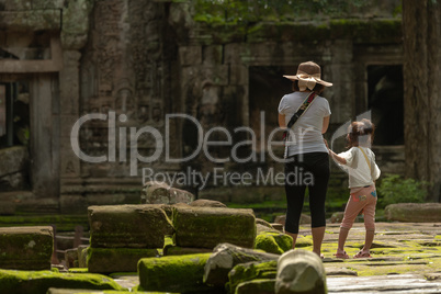Mother and daughter stand in mossy temple