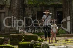 Mother and daughter stand on mossy flagstones