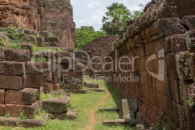 Path between stone wall and temple facade