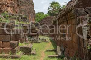 Path between stone wall and temple facade