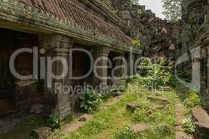 Roofed colonnade leading to pile of rocks