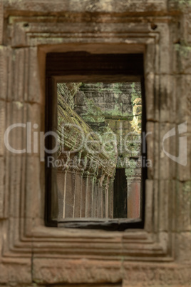 Ruined temple colonnade seen through stone window