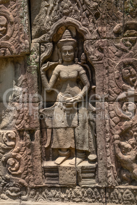 Statue of smiling man on temple wall