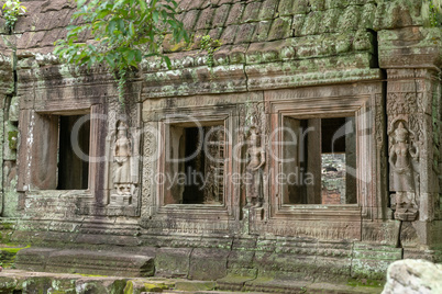 Three temple windows decorated with stone statues