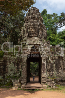 Tourist photographing stone entrance with Buddha face