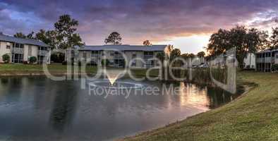 Overlooking a large pond with a fountain at sunset