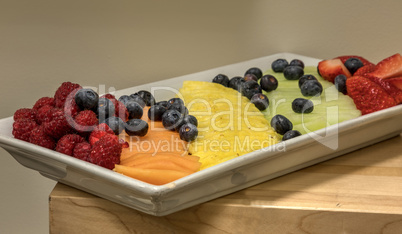 Fruit platter including raspberries, pineapple, blueberries, can