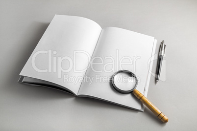 Book, magnifier, pencil