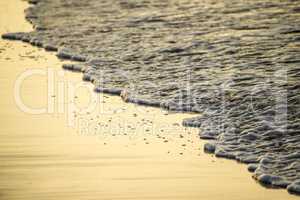 Sandy beach with shallow water of the surf