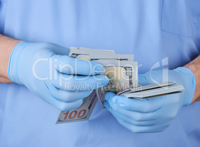 doctor in blue uniform and gloves recounts money