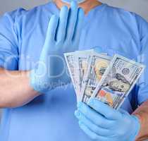 doctor in blue uniform and datex gloves holds a lot of paper mon