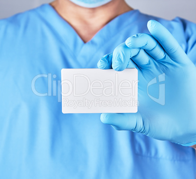 doctor wearing blue latex gloves is holding a blank white paper