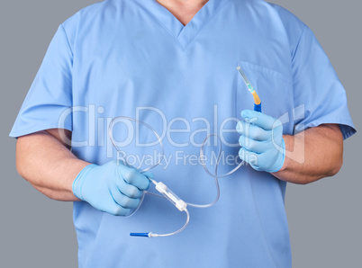 doctor with blue latex gloves and uniform holds medical equipmen