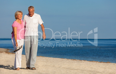 Happy Senior Couple Walking Laughing on a Beach