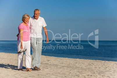 Happy Senior Couple Walking Laughing on a Beach