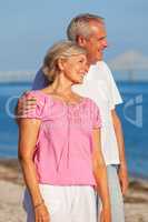 Happy Senior Couple Standing Embracing on a Beach