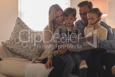 Family reading story book in living room
