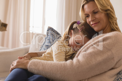 Mother embracing her sleeping daughter in arms