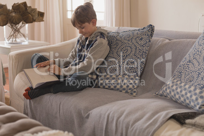 Boy reading a story book in living room