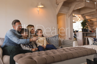 Family watching television in living room at home