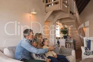 Family watching television in living room at home