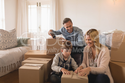 Family unpacking cardboard boxes in their new home