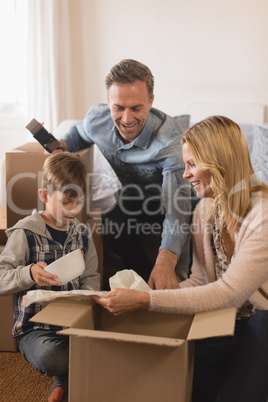 Family unpacking cardboard boxes in their new home