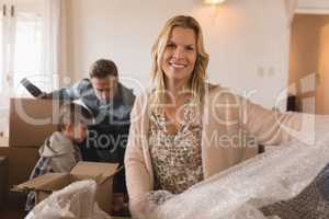 Family unpacking cardboard boxes in their new home