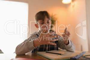 Boy counting on fingers while doing his homework