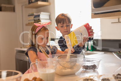 Siblings preparing food in kitchen