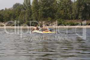 Teenager boys surfing on tropical beach in Europe. Kids on surf board on river wave. Active water sports for kids. Kid swimming with body board photo.