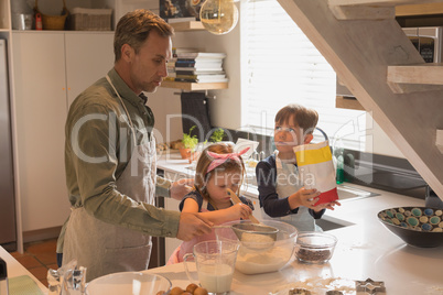 Father with his children preparing food in kitchen