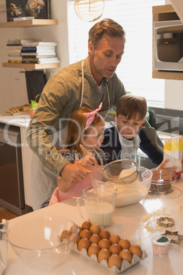 Father with his children preparing food in kitchen