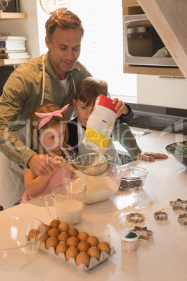 Father with his children preparing food in kitchen