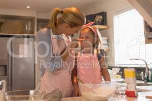Mother with her daughter preparing food in kitchen