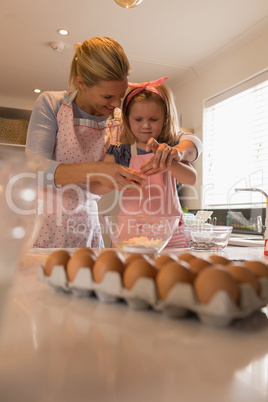 Mother with her daughter preparing food in kitchen