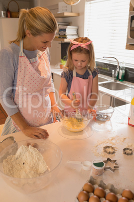 Mother with her daughter preparing food in kitchen